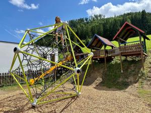 Ein Mann steht auf einer Spielplatzausrüstung in der Unterkunft Almresort Baumschlagerberg in Vorderstoder