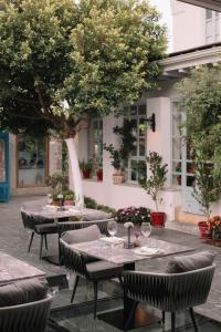 un restaurante al aire libre con mesas y sillas bajo un árbol en Kocadon Museum Hotel, en Bodrum City