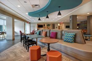 - une salle d'attente avec des tables, des chaises et un canapé dans l'établissement Home2 Suites By Hilton Atlanta Marietta, Ga, à Marietta