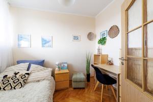 1 dormitorio con cama, escritorio y escritorio en Apartament 2 pokoje blisko morza 1000 metrów w Gdańsku, en Gdansk