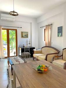 a living room with a table with a bowl of fruit on it at New Apt Close to Medical Center with Garden in Heraklio Town