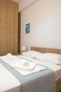 2 posti letto in camera con asciugamani di New Apt Close to Medical Center with Garden a Heraklion