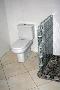 a bathroom with a toilet and a tile floor at Casa Golf in Costa Teguise