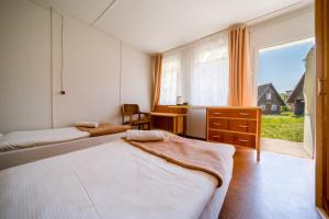 een slaapkamer met 2 bedden en een groot raam bij OW Gromada Pod Topolami in Międzyzdroje