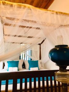 a bedroom with a bed with a white canopy at Museum Villa 09 in Beruwala
