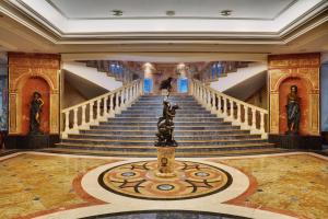 a lobby with stairs and a statue in the middle at Palm Royale Resort - Soma Bay in Hurghada