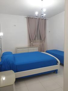 una camera con un letto blu e una finestra di La Ginestra ad Amalfi