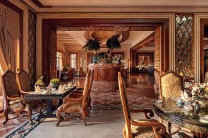 a living room with tables and chairs in a room at Palm Royale Resort - Soma Bay in Hurghada