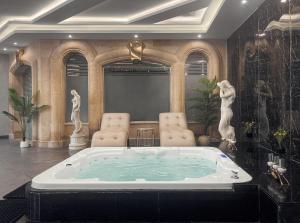a jacuzzi tub in a room with chairs at Palm Royale Resort - Soma Bay in Hurghada