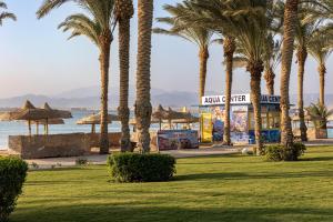 a park with palm trees on the beach at Palm Royale Resort - Soma Bay in Hurghada