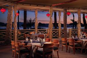 a restaurant with tables and chairs with a view of the ocean at Palm Royale Resort - Soma Bay in Hurghada
