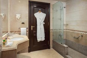 a bathroom with a white dress hanging on a door at Palm Royale Resort - Soma Bay in Hurghada