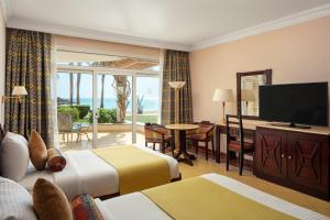 a hotel room with two beds and a flat screen tv at Palm Royale Resort - Soma Bay in Hurghada