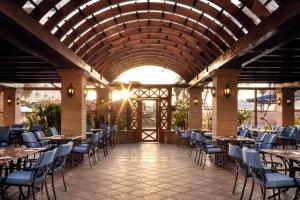 a restaurant with tables and chairs in a building at Palm Royale Resort - Soma Bay in Hurghada