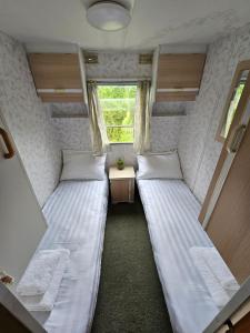 Duas camas num pequeno quarto com uma janela em Atvases em Liepāja