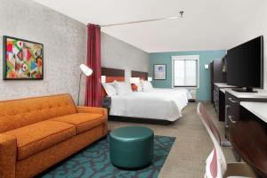 een hotelkamer met een bed en een bank bij Home2 Suites by Hilton Long Island Brookhaven in Yaphank