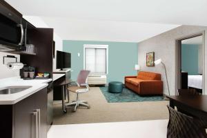 a hotel room with a kitchen and a living room at Home2 Suites by Hilton Long Island Brookhaven in Yaphank