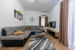 a living room with a couch and a tv at Villa Luma ZadarVillas in Gorica