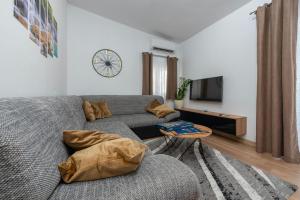 a living room with a couch and a clock on the wall at Villa Luma ZadarVillas in Gorica +72 photos