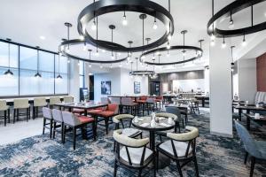 une salle à manger avec des tables, des chaises et des lustres dans l'établissement Hilton Garden Inn Pittsburgh Area Beaver Valley, Pa, à Monaca