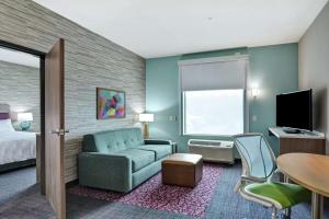 ペコスにあるHome2 Suites By Hilton Pecos Txのソファとベッド付きのホテルルーム