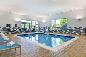 una piscina en un gimnasio con sillas y mesas en Homewood Suites By Hilton Lynchburg en Lynchburg