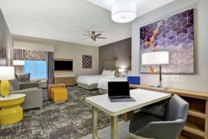 リンチバーグにあるHomewood Suites By Hilton Lynchburgのベッド、デスク、ノートパソコンが備わるホテルルームです。