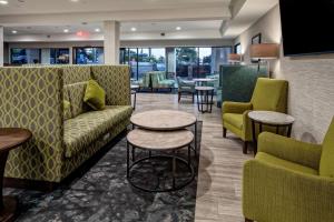 - une salle d'attente avec des canapés, des tables et des chaises dans l'établissement Hampton by Hilton Encinitas-Cardiff Beach Area, à Encinitas
