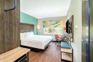 a hotel room with a bed and a chair at Tru By Hilton Greenville in Greenville