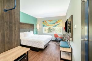 Habitación de hotel con cama y silla en Tru By Hilton Greenville en Greenville