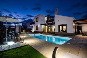 una villa con piscina di notte di Siesta Suites Lanzarote a Yaiza