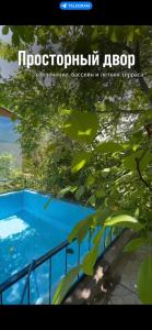 una imagen de una piscina azul con árboles en Бухта гостевой дом en Cholpon-Ata