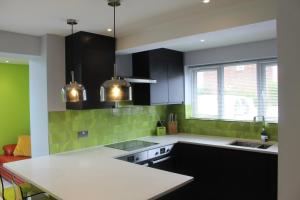 una cucina con armadi neri e piastrelle verdi di Modern Property Near Chichester & Goodwood Events with Garden, Great for Families! a Chichester