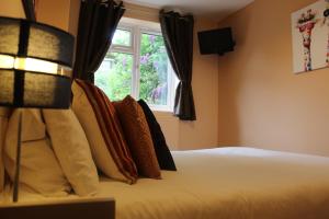 a bedroom with a bed with pillows and a window at Modern Property Near Chichester & Goodwood Events with Garden, Great for Families! in Chichester
