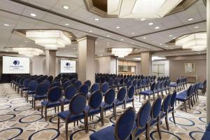 a conference room with blue chairs and a podium at DoubleTree by Hilton Newark Penn Station, NJ in Newark