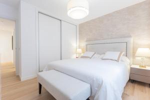 Dormitorio blanco con cama blanca grande y banco en The Terraces Luxury Penthouses, 3B, en Santa Cruz de Tenerife