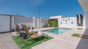 a patio with two chairs and a swimming pool at Ramales Alhaurín de la Torre by Ruralidays in Alhaurín de la Torre
