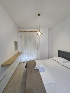 a bedroom with a large white bed and a window at Gex apartments in Tirana