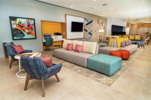 a living room with a couch and tables and chairs at Hilton Garden Inn Cedar Park Austin in Austin