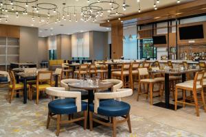 um restaurante com mesas e cadeiras e um bar em Hilton Garden Inn Cedar Park Austin em Austin