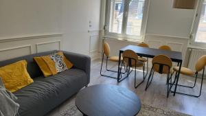 ein Wohnzimmer mit einer Couch und einem Tisch und Stühlen in der Unterkunft Appartements Rue du Chêne in Mulhouse + 79 Fotos