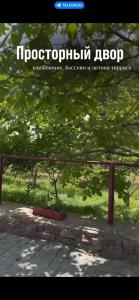 een bord voor de dierentuin met bomen en gras bij Бухта гостевой дом in Cholpon-Ata