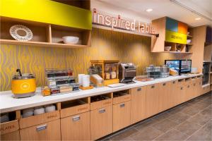 a kitchen with wooden cabinets and a prepared table at Home2 Suites Bakersfield in Bakersfield