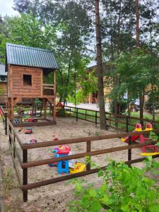 um parque infantil com uma estrutura de brincar e uma cerca de madeira em База відпочинку Діана em Szack