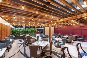 un restaurante con techos de madera, mesas y sillas en The Burgundy Hotel, Tapestry Collection by Hilton, en Little Rock