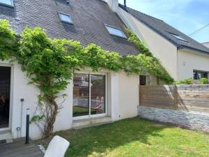 a white house with a tree in the yard at Maison Familiale - Plage à Pieds in Larmor-Plage