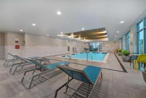 a swimming pool with chairs and a swimming pool at Home2 Suites By Hilton Memphis Wolfchase Galleria in Memphis