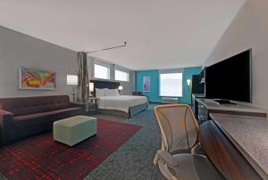 a hotel room with a couch and a bed and a television at Home2 Suites By Hilton Memphis Wolfchase Galleria in Memphis