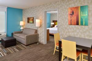 a hotel room with a bed and a table and a chair at Home2 Suites By Hilton Portland Hillsboro in Hillsboro