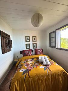ein Schlafzimmer mit einem großen Bett und einer gelben Decke in der Unterkunft LES CASES METISSES in Saint-Louis